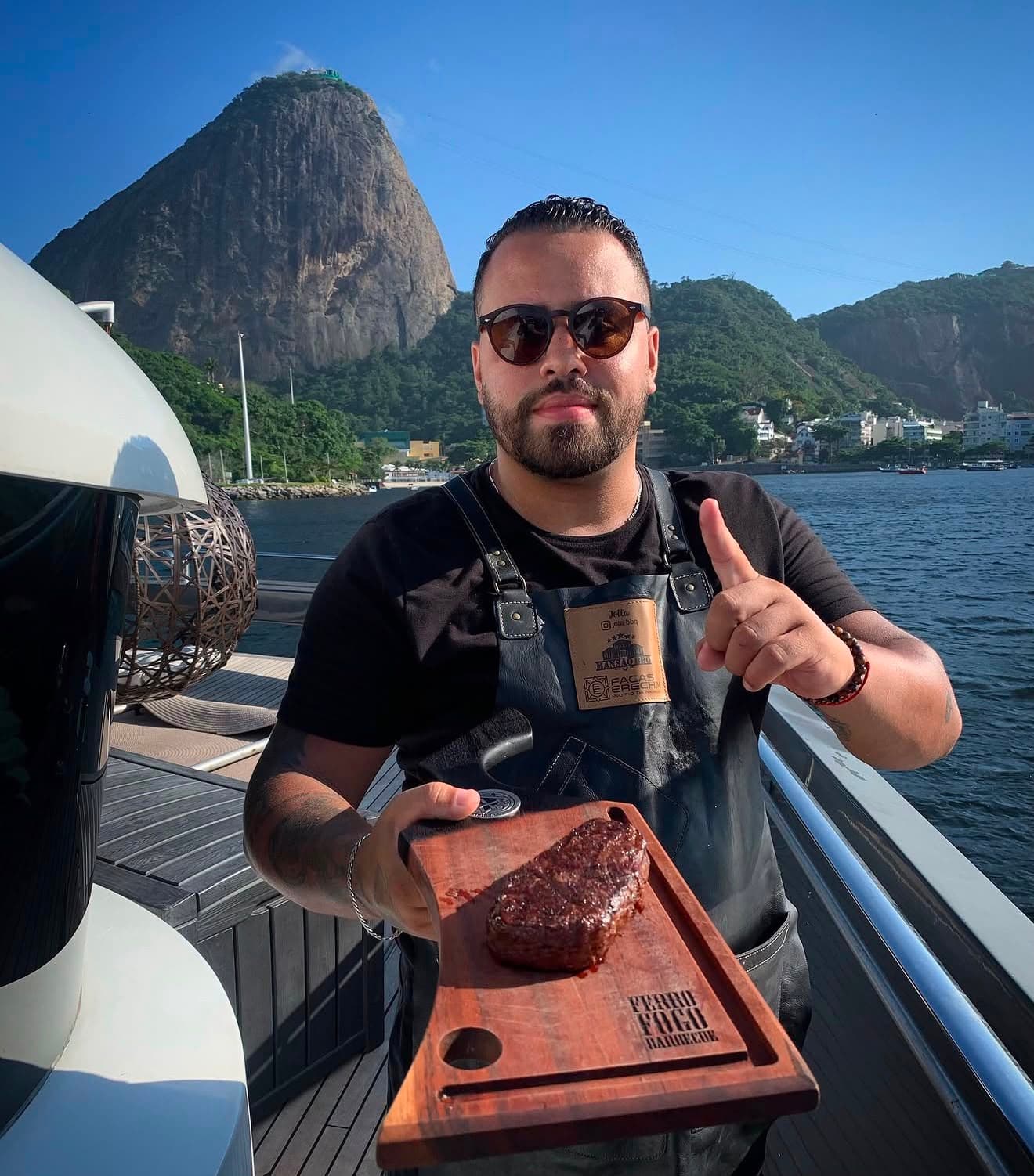 Jota Albuquerque servindo um corte nobre a bordo, com o Pão de Açúcar ao fundo, no Rio de Janeiro