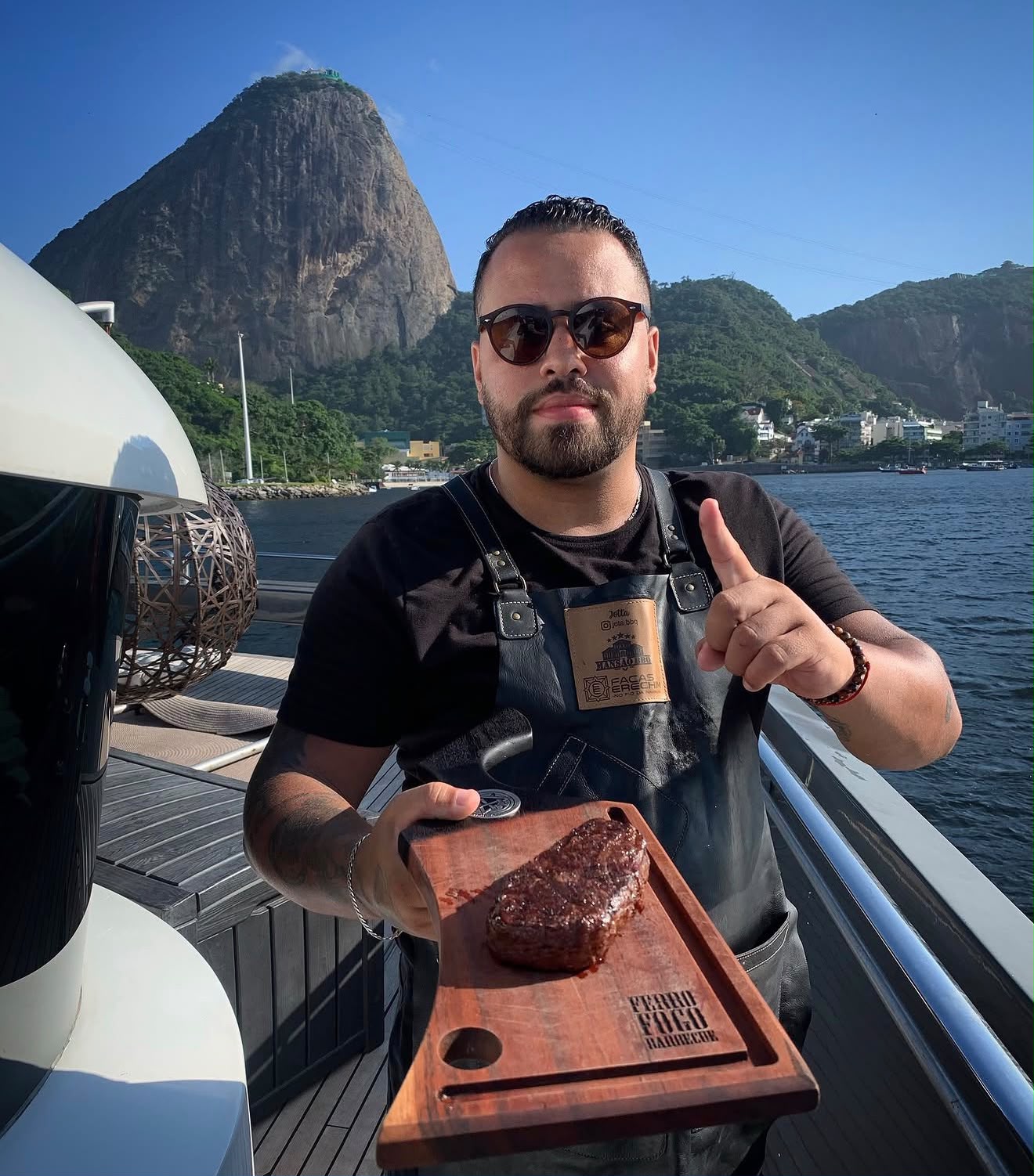 Jota Albuquerque servindo um corte nobre a bordo, com o Pão de Açúcar ao fundo, no Rio de Janeiro